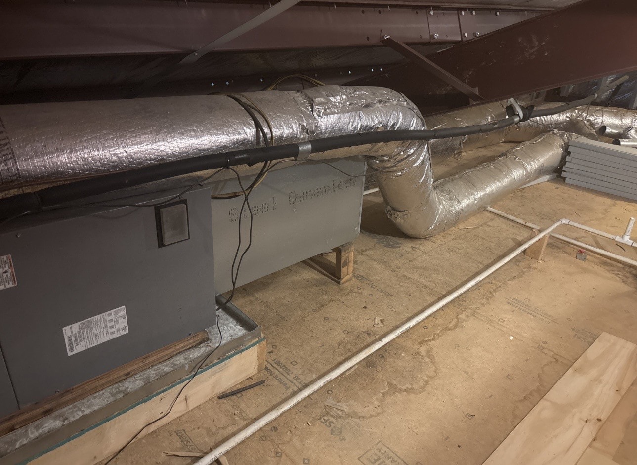 Horizontal attic air handler in a Benton, Arkansas home with foil-wrapped insulated flexible ductwork, properly supported where the main run leaves the plenum.