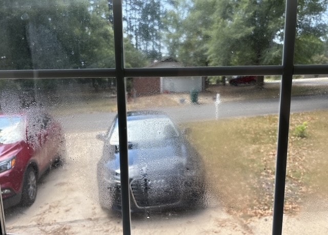 Double-glazed window with heavy condensation trapped between the panes from a failed insulated glass unit seal.
